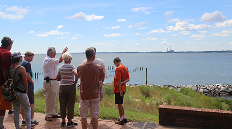 Former volunteer Lou Schiavo interprets the York River coastline for a group of public tour attendees.