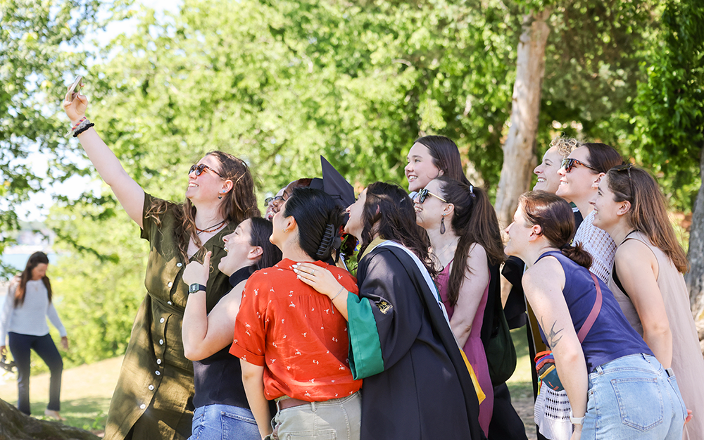 Students at the outdoor reception take a selfie to commemorate the occasion. Photo by Candace Johnson.