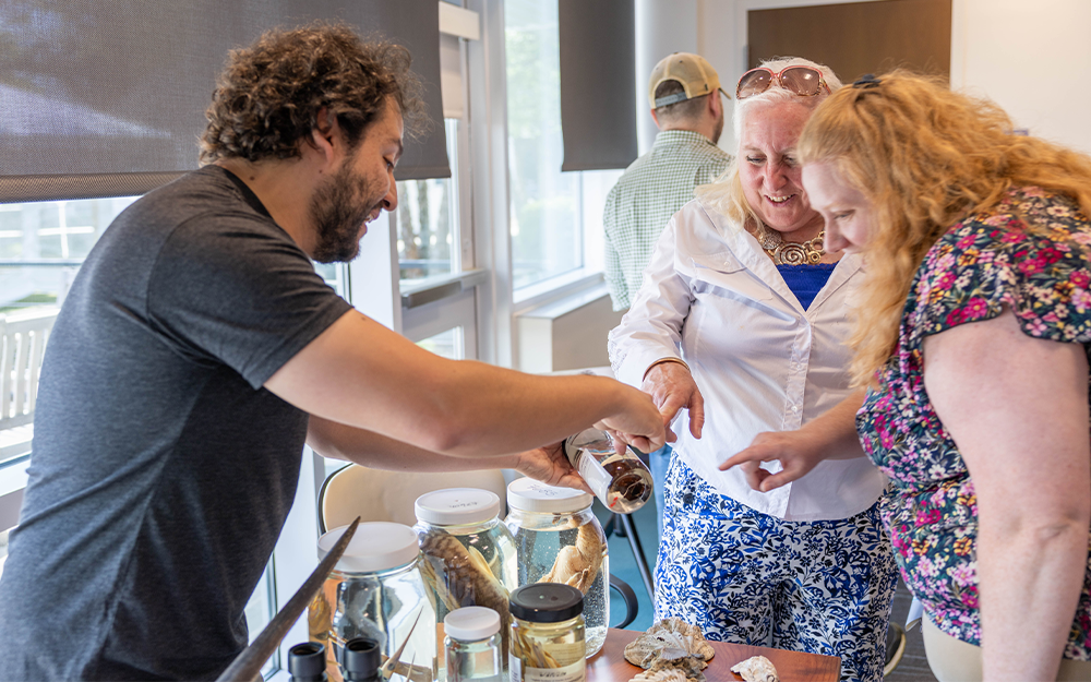 Ph.D. student Miguel Montalvo shows specimens to a pair of teachers at the Lesson Plan Expo. Photo by Bayleigh Albert, VA Sea Grant.