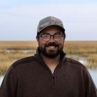William Sayers standing in front of some wetlands